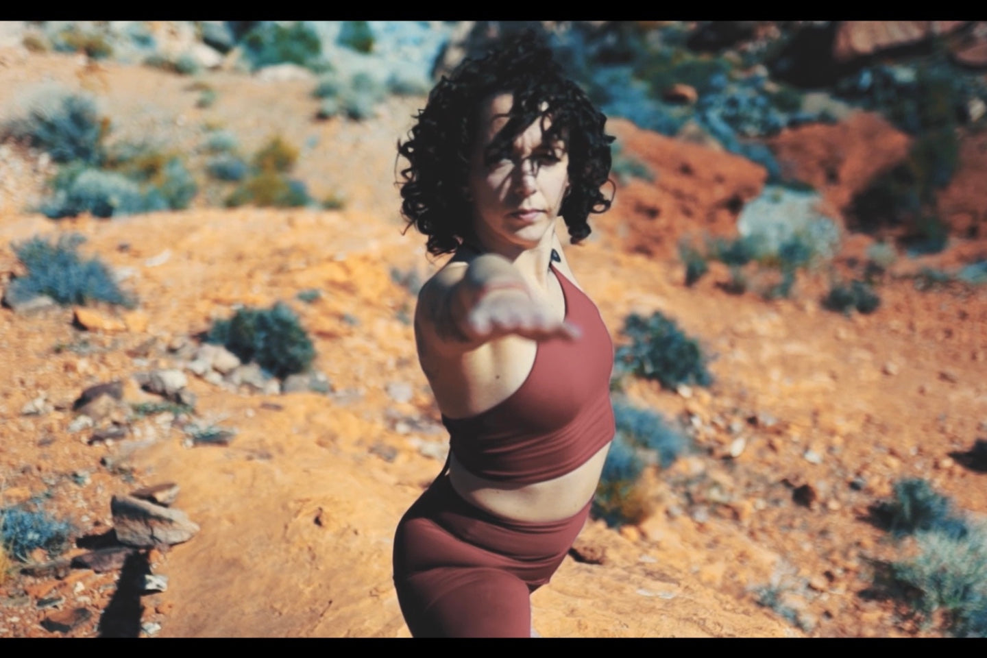 Carregar vídeo: no deserto de las vegas, nevada, nos estados unidos, a instrutora de yoga faz sua pratica ao nascer do sol, vestindo uma roupa vermelha com tom vermelho queimado: uma legging cintura alta e um top de amarrar com decote nas costas.